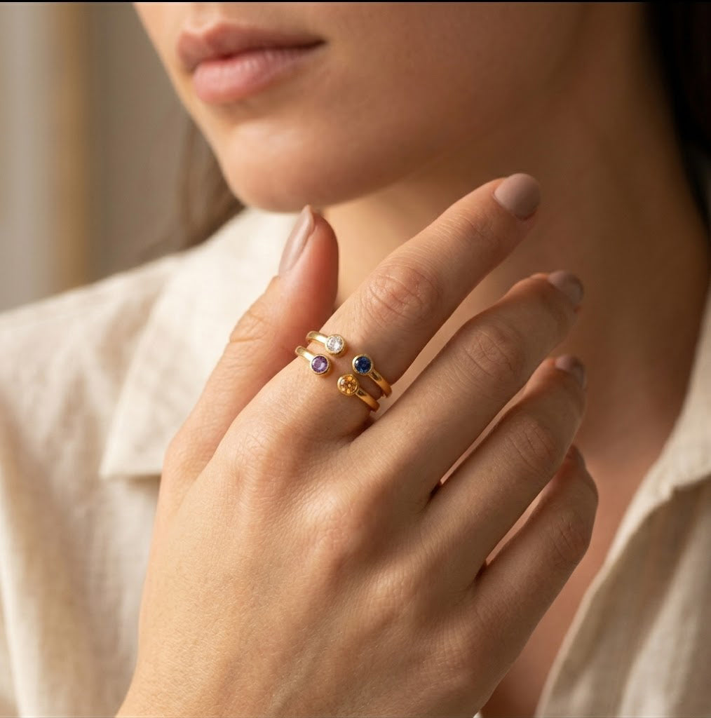 Minimalist gold birthstone ring with two natural gemstones worn on hand, delicate personalized jewelry designed for stacking and everyday elegance