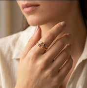 Minimalist gold birthstone ring with two natural gemstones worn on hand, delicate personalized jewelry designed for stacking and everyday elegance