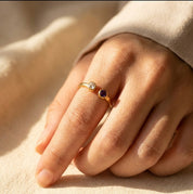 Woman wearing a dainty adjustable birthstone ring with two natural gemstones, elegant stacking ring for everyday wear and personalized jewelry styling