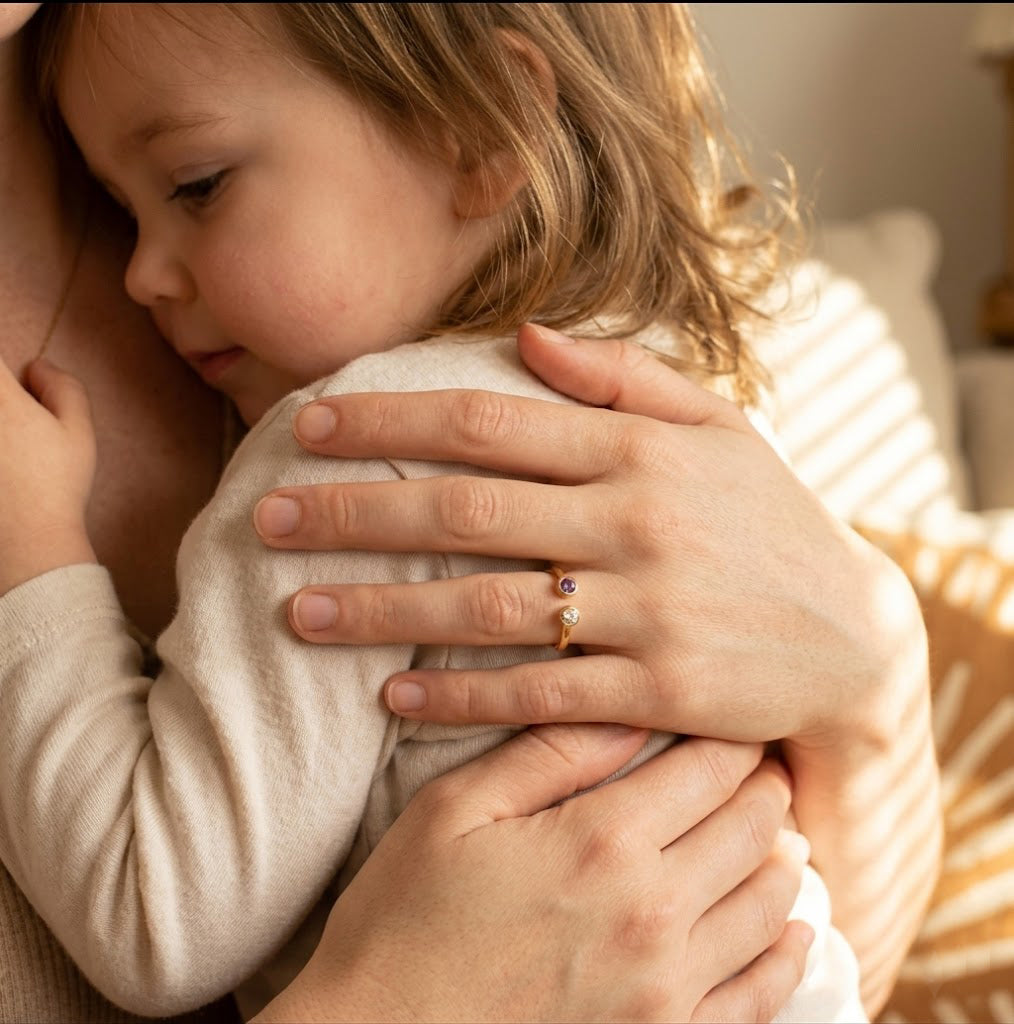 Mother wearing a personalized birthstone ring with natural gemstones, meaningful jewelry representing children or family connection