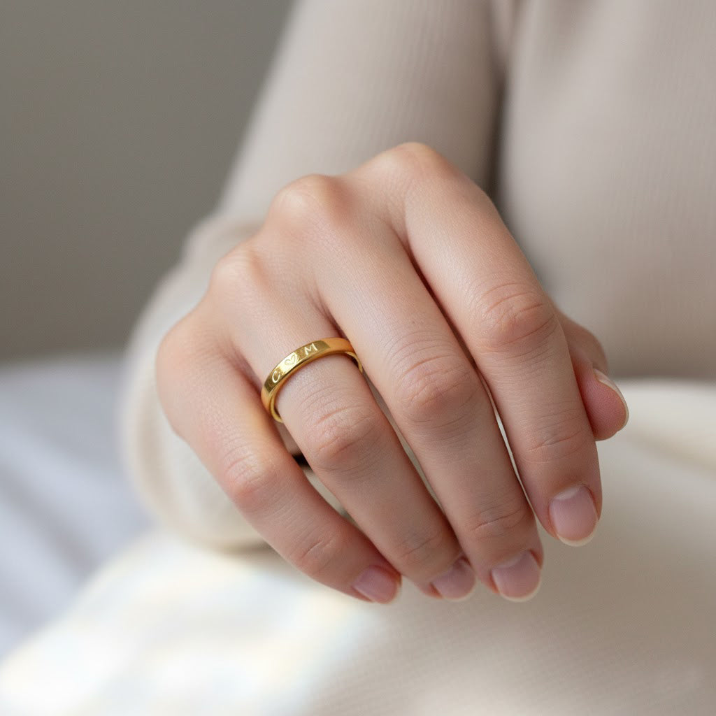 Custom 3mm gold engraved ring with text personalization shown on white background. Slim and minimalist unisex band designed for engraving names, dates, or meaningful phrases. Perfect as a wedding band, promise ring, or everyday stacking ring, this dainty engraved band is available in sterling silver, gold, or rose gold. A meaningful keepsake gift crafted with precision engraving and timeless design for couples or individuals.