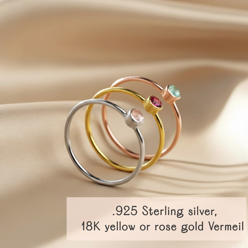 Gold, sterling silver, and rose gold tiny birthstone rings stacked together, showing metal and gemstone options for custom mom or grandma birthstone jewelry.
