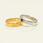 Custom handwriting engraved rings in gold and silver with visible cursive text personalization. Slim 4mm unisex bands designed for names, dates, or meaningful phrases. Ideal as personalized wedding bands, promise rings, or anniversary gifts, these engraved rings capture handwriting or coordinates for a deeply meaningful keepsake. Handmade in sterling silver, gold, or rose gold with lasting engraving detail.
