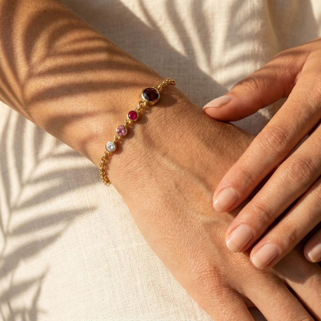 Close-up of gold birthstone bracelet for mom with kids birthstones and engraved initials, elegant Mother’s Day jewelry gift for mothers and grandmothers
