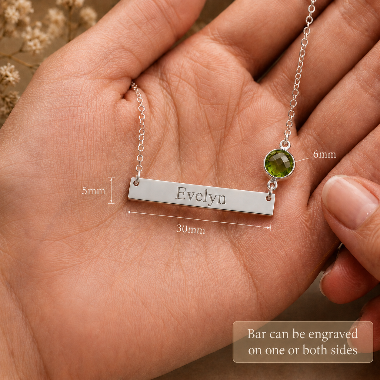 Engraved bar necklace shown front and back with Evelyn name and green birthstone