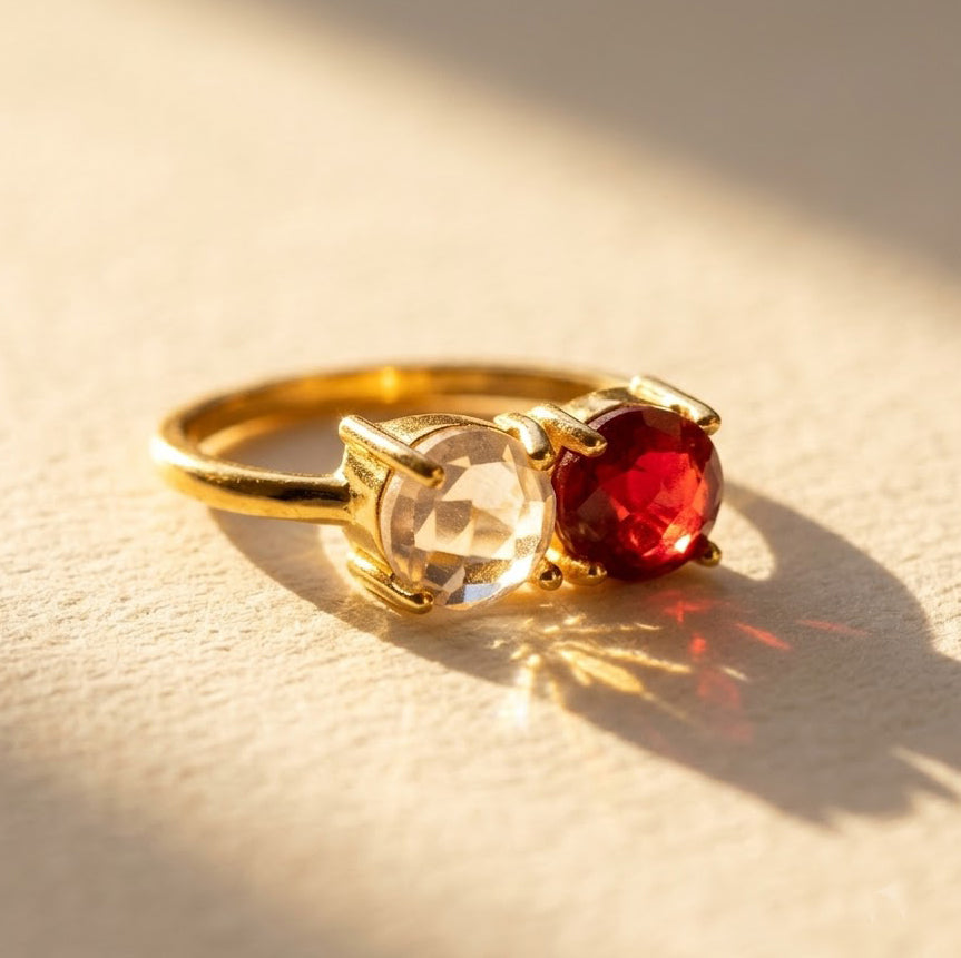 Custom two birthstone ring with faceted clear quartz and ruby gemstones in yellow gold.