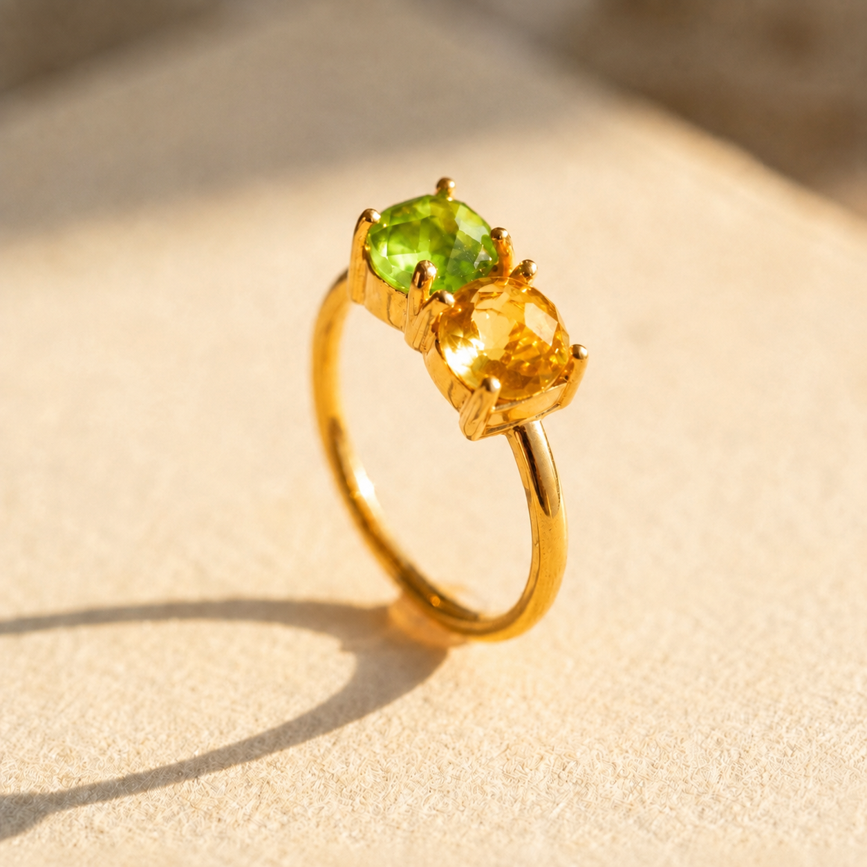 Gold two birthstone ring with peridot and citrine faceted gemstones in prong settings.