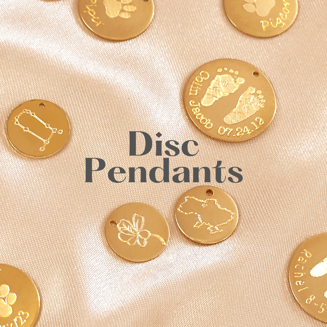 Gold disc pendants with engraved designs like paw prints, footprints, and names, scattered on a beige satin fabric background with text overlays indicating sizes 13mm, 16mm, and 19mm.
