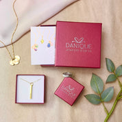 3 red Danique Jewelry boxes against a tan background. birthstone jewelry for families, personalized family birthstone necklace, custom family tree jewelry, engraved birthstone pendant, gold family tree necklace, custom made family jewelry, personalized jewelry for mom, custom necklace with initials, family tree pendant for mom, custom family keepsake jewelry, personalized gifts for special occasions, handmade personalized jewelry, family tree necklace with birthstones, customized gold family necklace, 