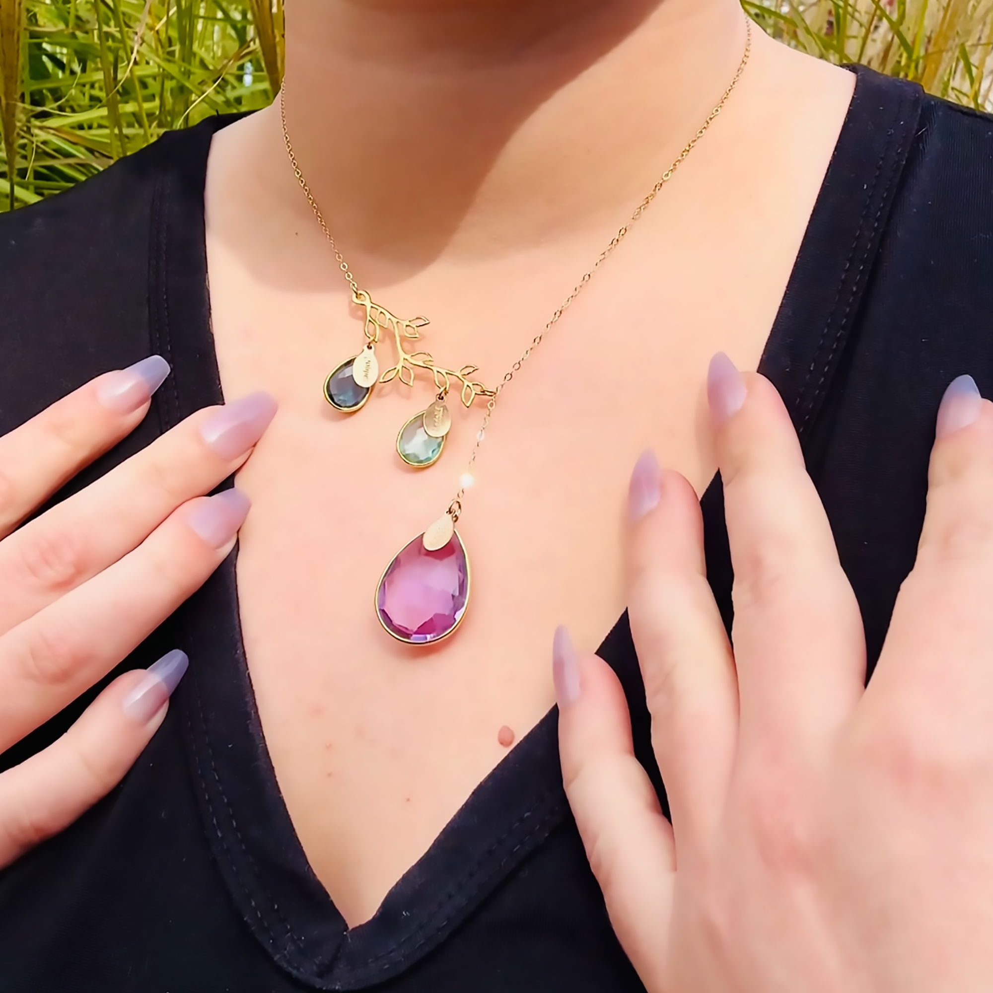 Lariat_branch_necklace_with_birthstones_and_oval_name_tag_charms_on_person.png