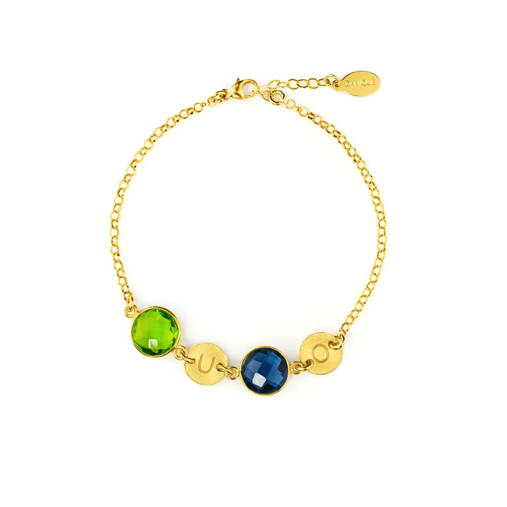 A gold bracelet featuring peridot quartz and kyanite quartz rests on a white background. Each birthstone is accompanied by a round disc charm with an initial hand stamped into it. August birthstone and September birthstone, green gemstone, blue gemstone, custom made personalized mother's bracelet with birthstones