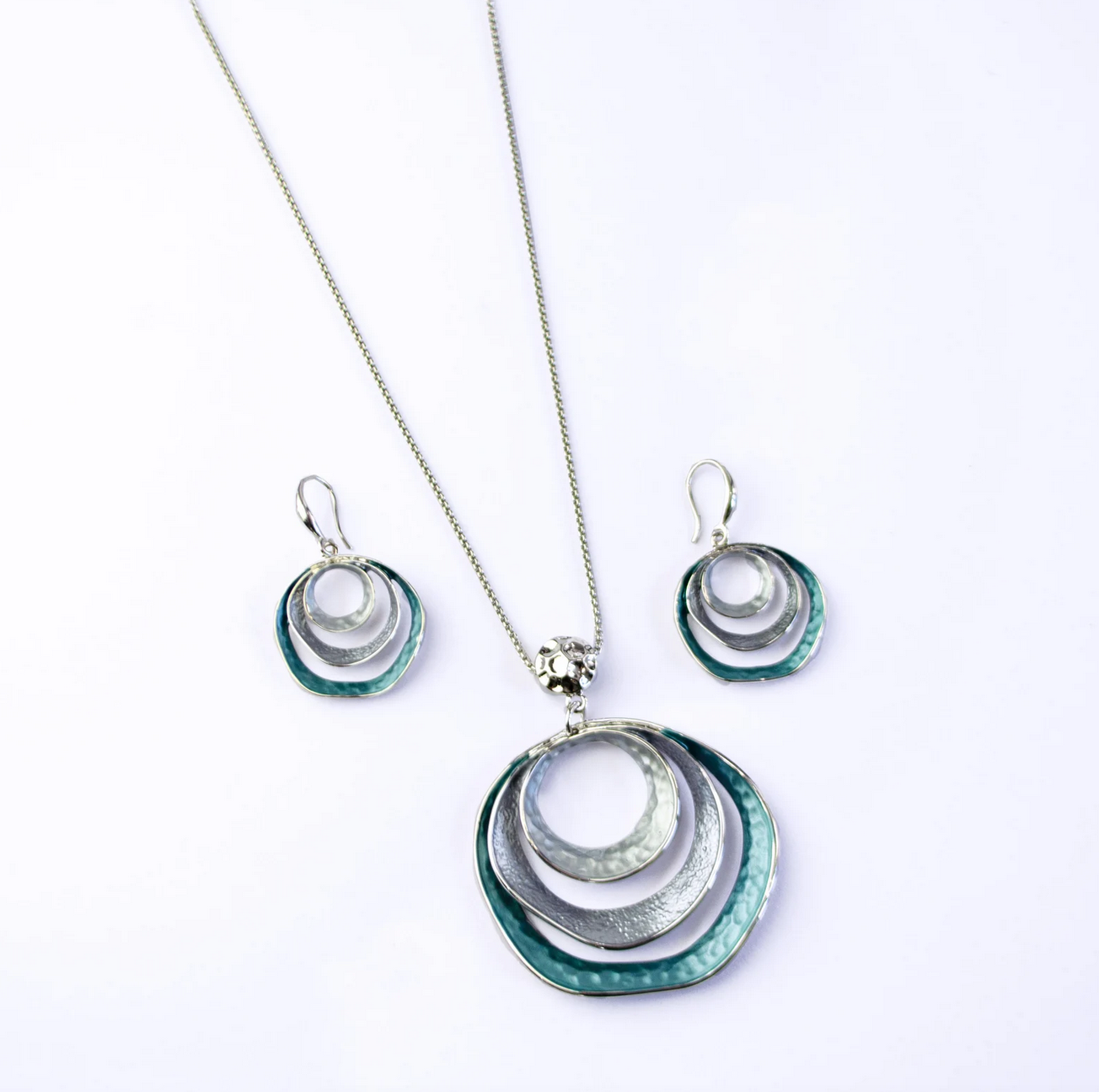 beautiful three-ring circles statement necklace and earrings set with silver and blue tones. Necklace is made with a steel cable chain and a zinc alloy pendant with a galvanic finish. boho necklace, boho jewelry, bohemian statement jewelry