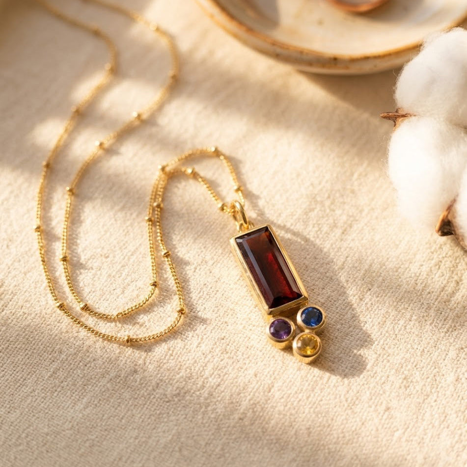 Mother and child lifestyle photo featuring a custom birthstone family necklace with a baguette mom stone and small kids’ birthstone charms.