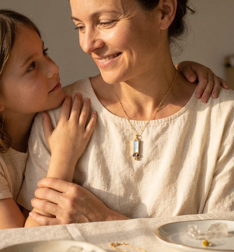 Personalized birthstone necklace for mom with one baguette stone representing the mother and tiny round charms representing children, designed for everyday wear.
