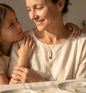 Personalized birthstone necklace for mom with one baguette stone representing the mother and tiny round charms representing children, designed for everyday wear.