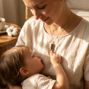Close-up of custom birthstone mom necklace with opal-style baguette charm and tiny purple and golden birthstone charms for children on a dainty chain.