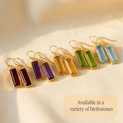Colorful baguette birthstone bar earrings displayed in multiple gemstone colors with text noting variety of birthstones available.