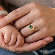 Woman wearing a personalized adjustable family birthstone ring with one Mom stone and three kids gemstones.
