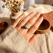 Oval amazonite cabochon ring worn on the hand, showcasing a smooth turquoise gemstone set in a minimalist gold bezel band. Dainty gemstone ring designed for everyday wear, modern styling, and meaningful gifting. Elegant amazonite jewelry ideal as a gift for her, a birthstone-inspired ring, or a timeless minimalist statement piece.