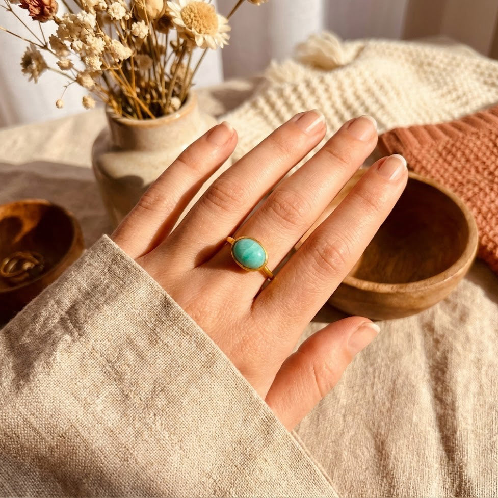 Oval amazonite cabochon ring worn on the hand, showcasing a smooth turquoise gemstone set in a minimalist gold bezel band. Dainty gemstone ring designed for everyday wear, modern styling, and meaningful gifting. Elegant amazonite jewelry ideal as a gift for her, a birthstone-inspired ring, or a timeless minimalist statement piece.