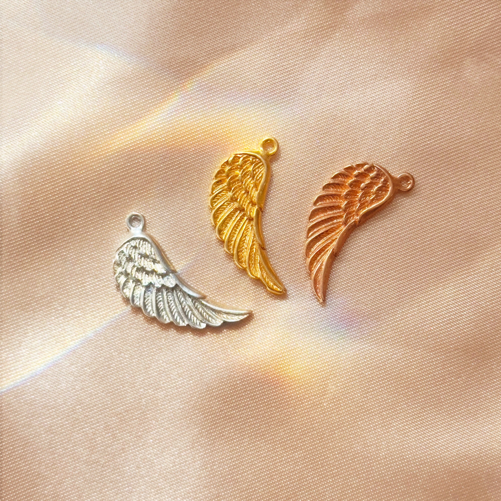 Gold and silver angel wing charms displayed with customizable options for initial and natural birthstone teardrop, ideal for creating a unique memorial necklace.