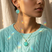 Model wearing aqua chalcedony necklace in gold soft blue green gemstone March birthstone pendant