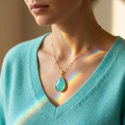 Close up aqua chalcedony necklace on neckline delicate blue gemstone pendant March birthstone gift