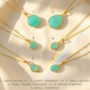 Aqua chalcedony necklaces displayed on soft fabric blue green gemstone pendants in gold