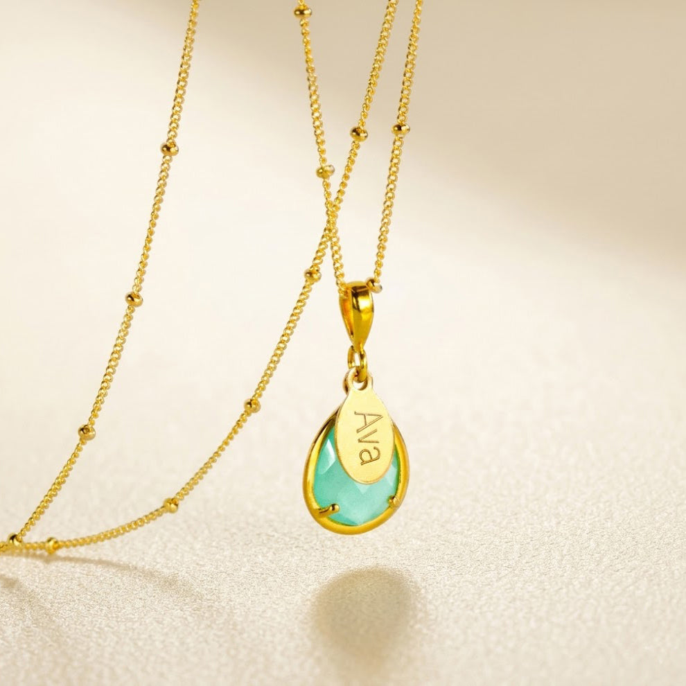 Personalized aqua chalcedony name necklace in gold with engraved oval charm and teardrop March birthstone pendant