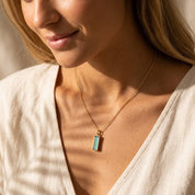Model wearing a March birthstone bar necklace with aqua chalcedony pendant and personalized side engraving.
