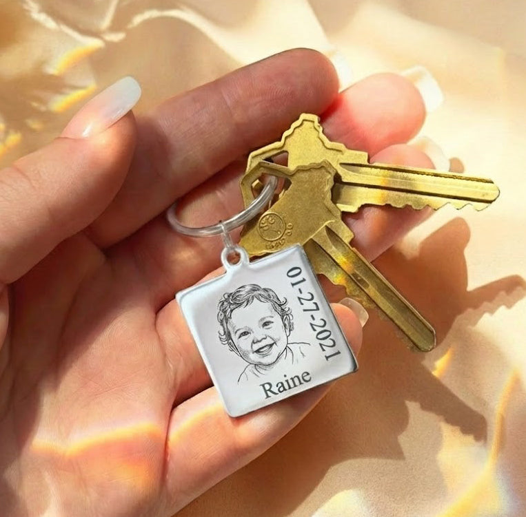 Actual baby photo keychain engraved from a real photograph, shown held in hand with a square stainless steel charm featuring a baby portrait. This personalized baby picture keychain transforms a meaningful photo into a lasting keepsake for a new mom, grandma, or loved one. A sentimental custom photo keychain designed as a newborn keepsake gift, memorial jewelry piece, or Mother’s Day gift for moms who cherish baby memories.