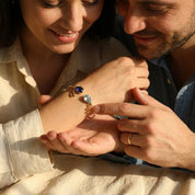 Couple holding hands with personalized birthstone initial bracelet, a romantic anniversary or him and her jewelry gift.