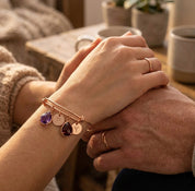 Personalized birthstone bangle bracelet with custom initial charms worn as a sentimental  gift for couples.