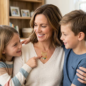 Mother wearing personalized birthstone name necklace with children, custom mom necklace with engraved bars and gemstone charms.