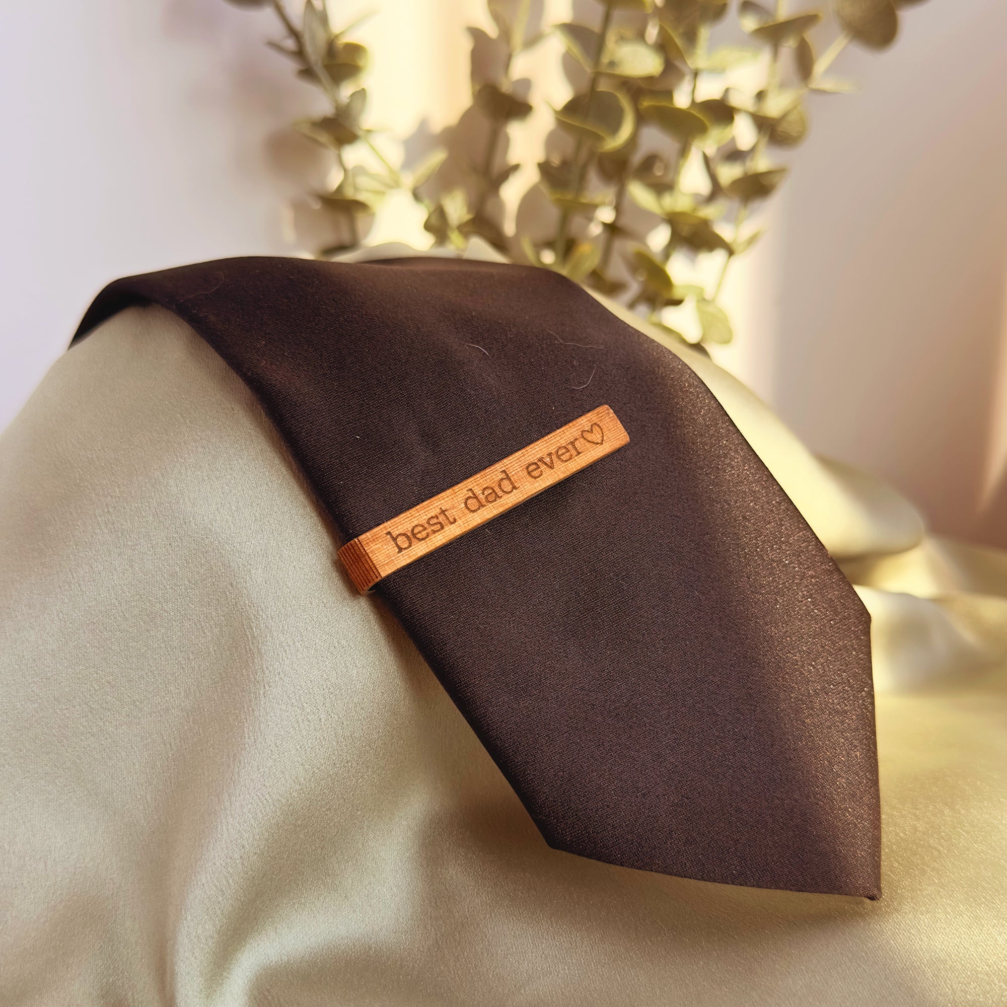 Mahogany wood tie clip with custom engraving best dad ever, placed on brown necktie. Rustic yet refined accessory, ideal as a groom or groomsmen gift, Father’s Day present, 5th anniversary wood gift, or graduation keepsake. Perfect for adding a personalized touch to men’s formal wear, business meetings, weddings, and special celebrations.