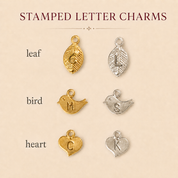 Stamped letter charm chart showing leaf, bird, and heart initial charm styles in gold and silver finishes.