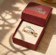 Gift-ready birthstone initial stacking rings displayed in Danique Jewelry box with colorful stones and custom leaf charms.