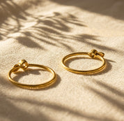 Pair of stackable birthstone initial rings in gold and sterling silver with small gemstone settings and leaf charms.