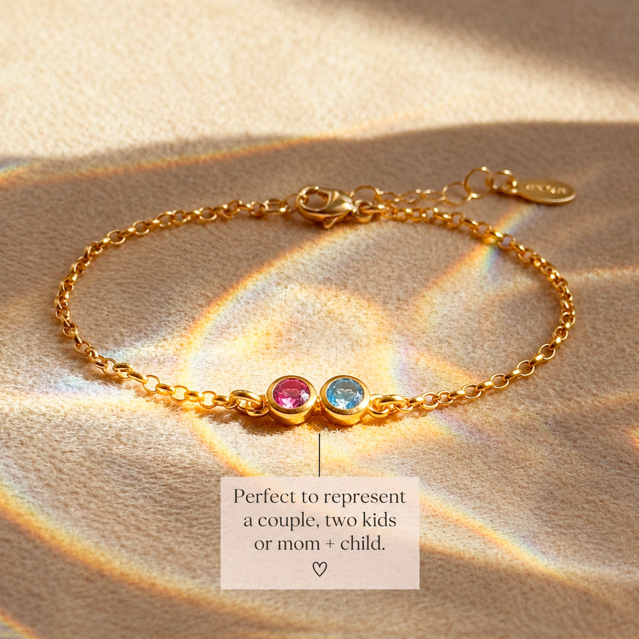 Personalized two birthstone bracelet in gold laid flat on neutral fabric
