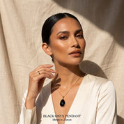 Model wearing black onyx teardrop pendant necklace in gold vermeil, elegant black gemstone necklace for women, minimalist dainty onyx jewelry, timeless statement pendant, gift for her, everyday black stone necklace for layering, refined modern jewelry styling for weddings, anniversaries, birthdays, or chic capsule wardrobe looks