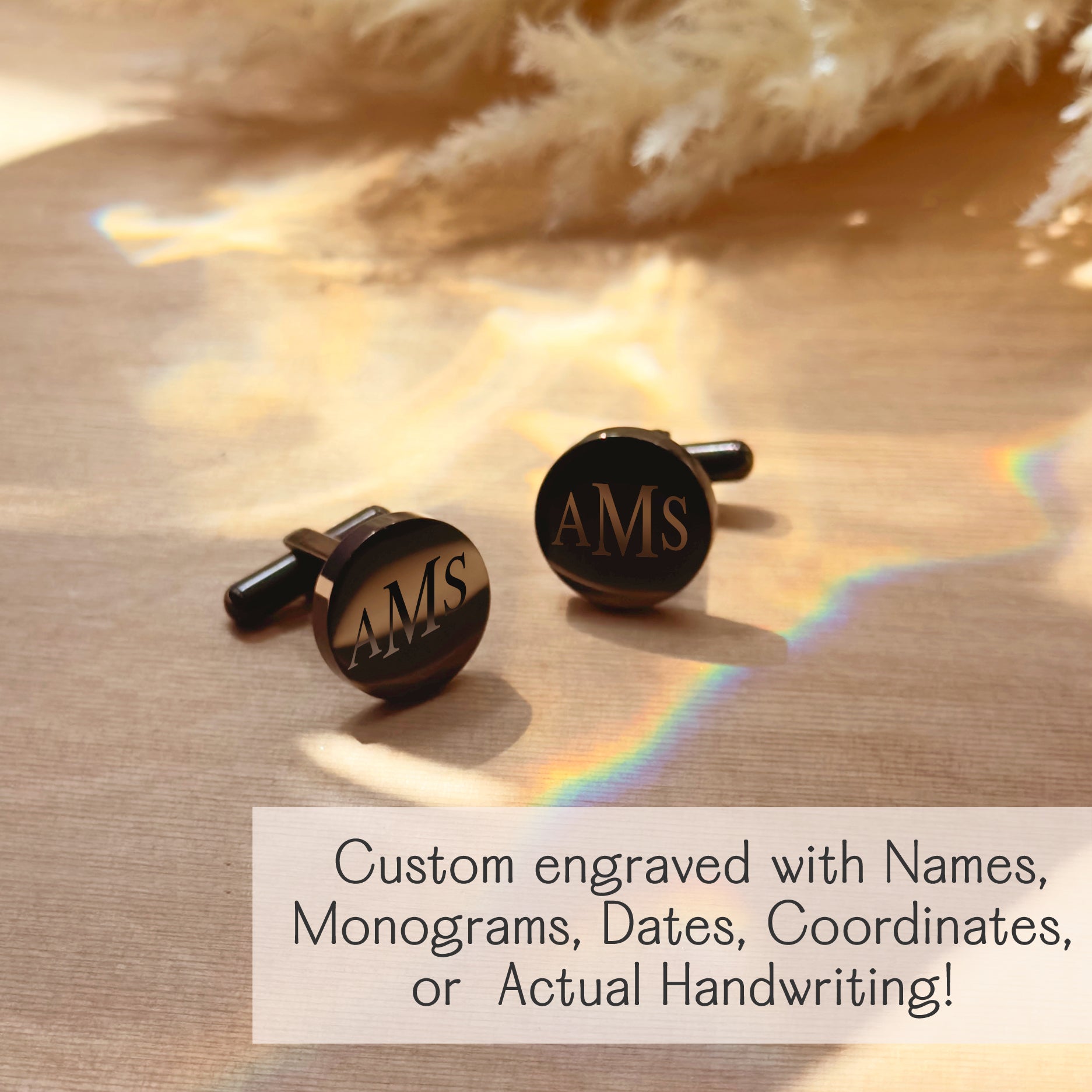 Pair of black round cufflinks engraved with initials “AMS,” displayed on a wood surface with soft light and rainbow reflection. These custom cuff links are available in gold, silver, or black finishes, and in both round and square shapes. Personalized with names, monograms, coordinates, dates, or actual handwriting. A stylish and meaningful men’s gift for weddings, anniversaries, graduations, or Father’s Day. Unique engraved men’s accessories and keepsake gifts for groomsmen or special occasions.