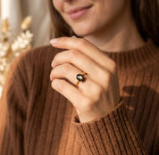 Woman wearing a dainty Black Star Sapphire ring in gold vermeil
