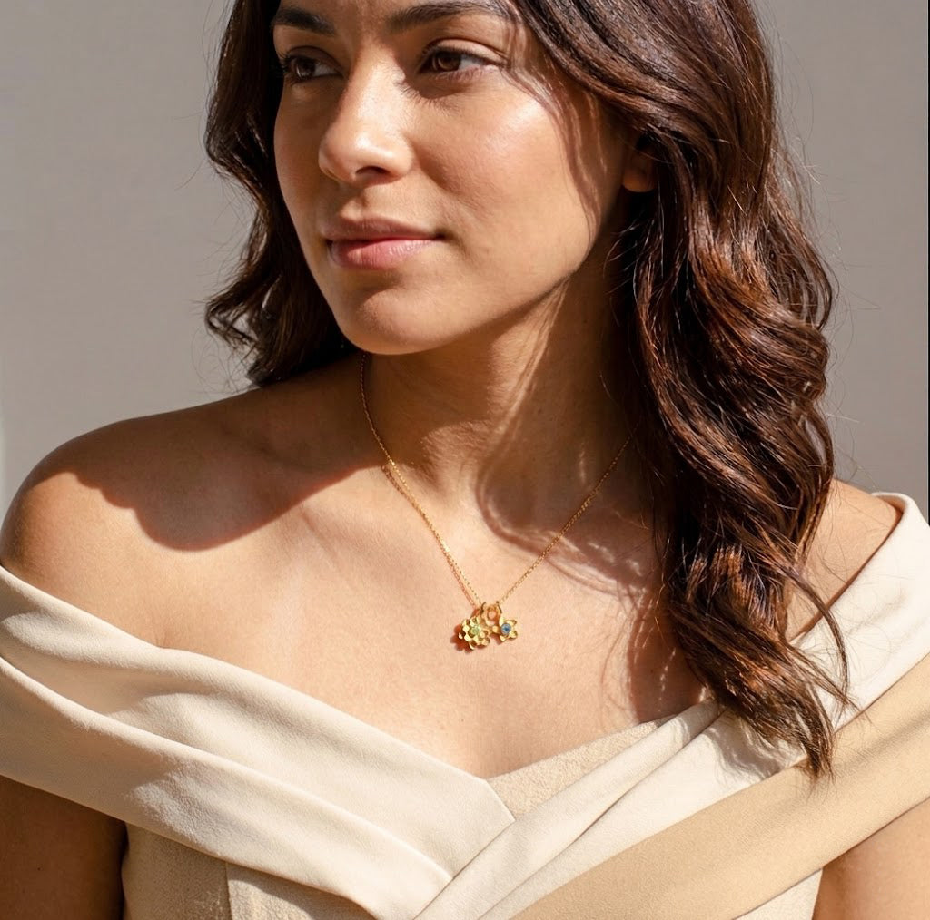 Model wearing dainty birthstone flower charm necklace in gold, personalized floral jewelry gift for mom or grandma.