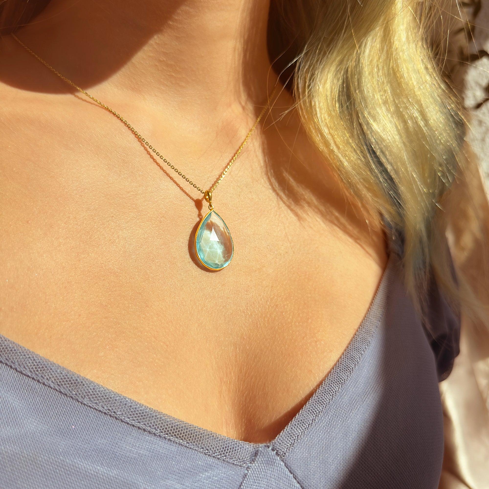 Blue topaz gemstone necklaces arranged flat lay, light blue December birthstone jewelry display