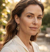 Woman wearing gold coral branch earrings with matching nature inspired necklace