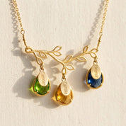 Personalized family tree birthstone necklace with branch pendant, engraved children’s names and colorful teardrop gemstones in gold.
