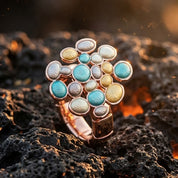 Bubble Cluster adjustable statement ring with aqua blue gold and pearl round accents displayed on dark textured stone