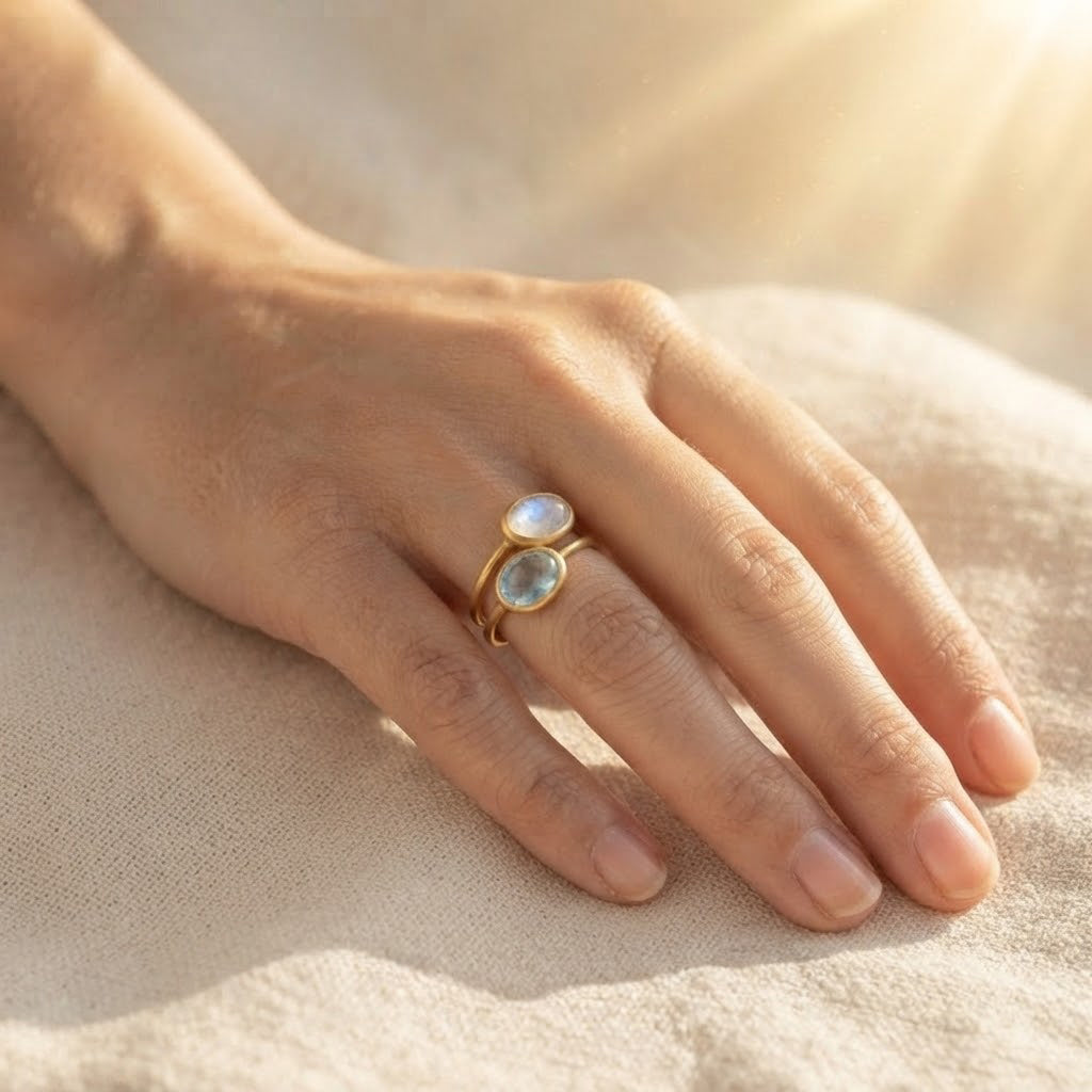 Stack of colorful oval cabochon birthstone rings in yellow gold bezel settings