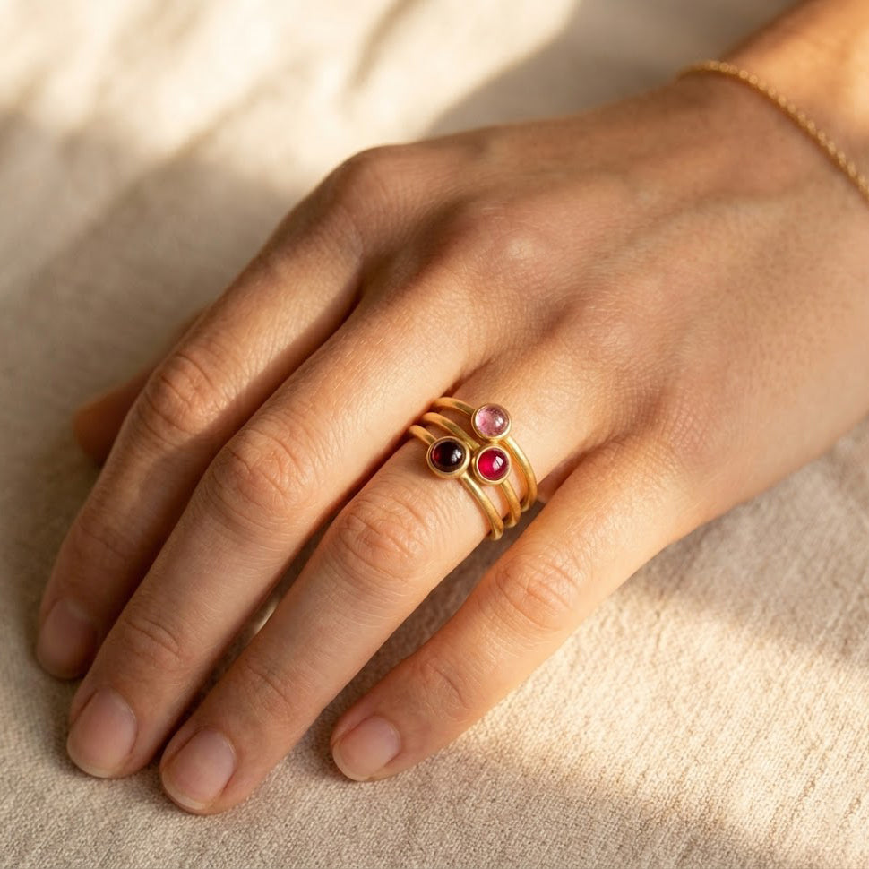 Custom birthstone ring worn on hand with two colorful gemstone rings, a meaningful family birthstone jewelry gift.