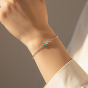 Delicate cabochon birthstone bar bracelet worn on wrist, showcasing tiny round stones set in a slim gold chain, adjustable fit for everyday wear, minimalist jewelry gift for her, bridesmaids or best friend, available in sterling silver, gold and rose gold.